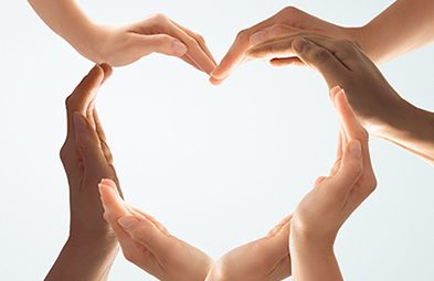 Symbol and shape of heart created from hands.